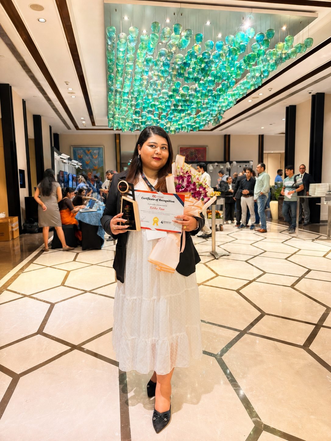 Ritika Rose with her Certificate of Recognition, trophy and bouquet at DIGITALCONFEX 2026